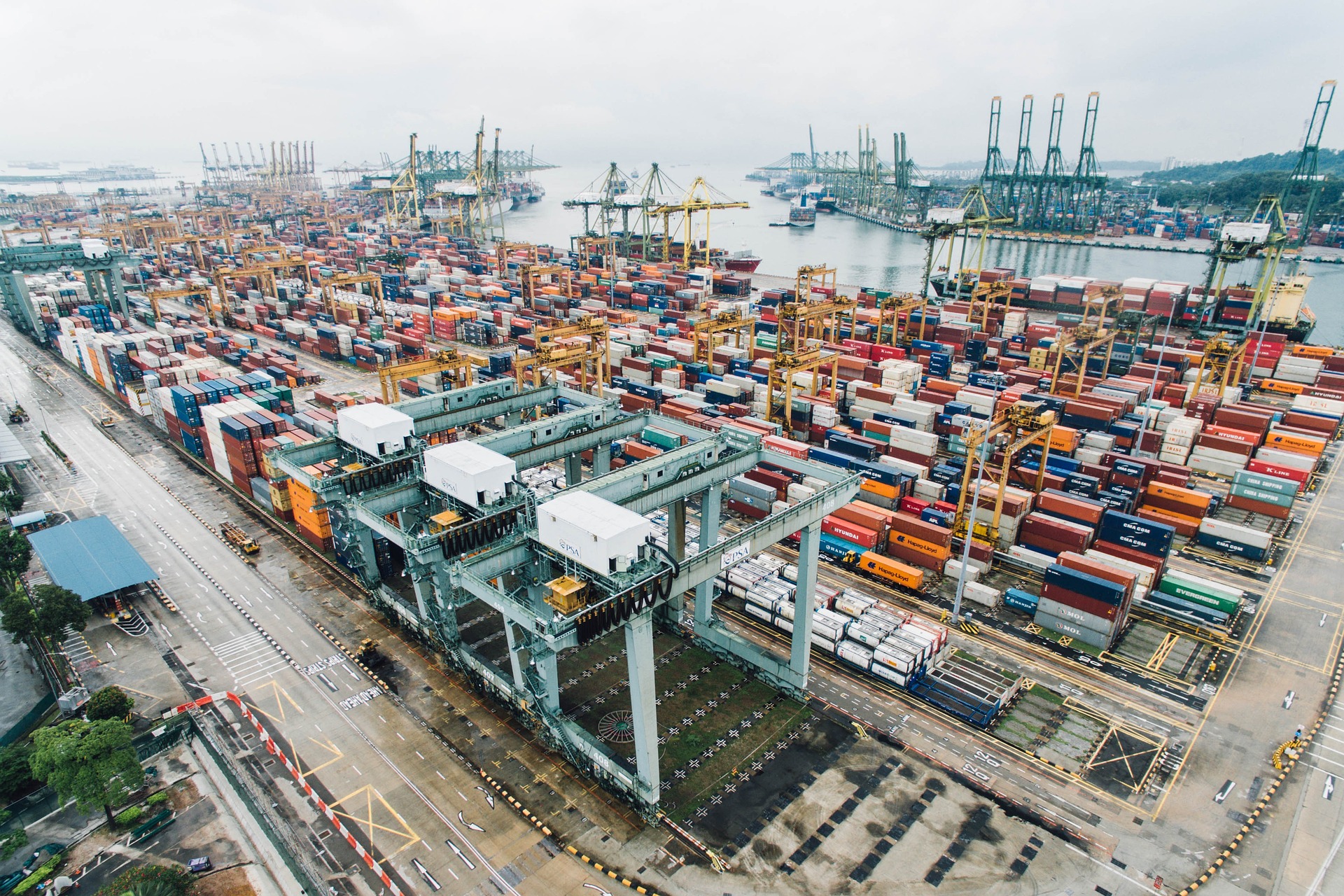International shipping port at dusk — containers, cranes, and cargo vessels