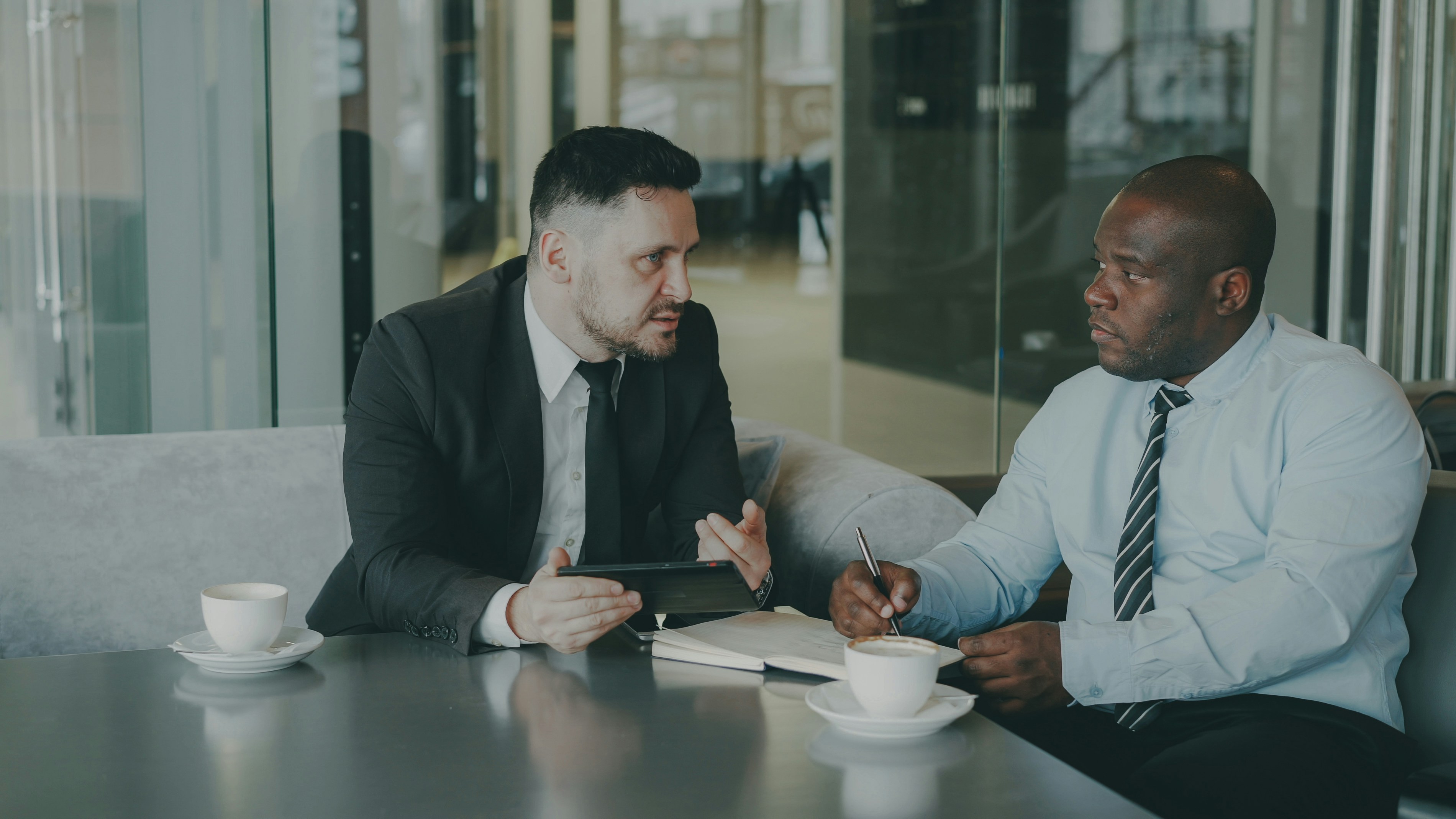 Business meeting in corporate boardroom — executives reviewing documents, professional advisory session