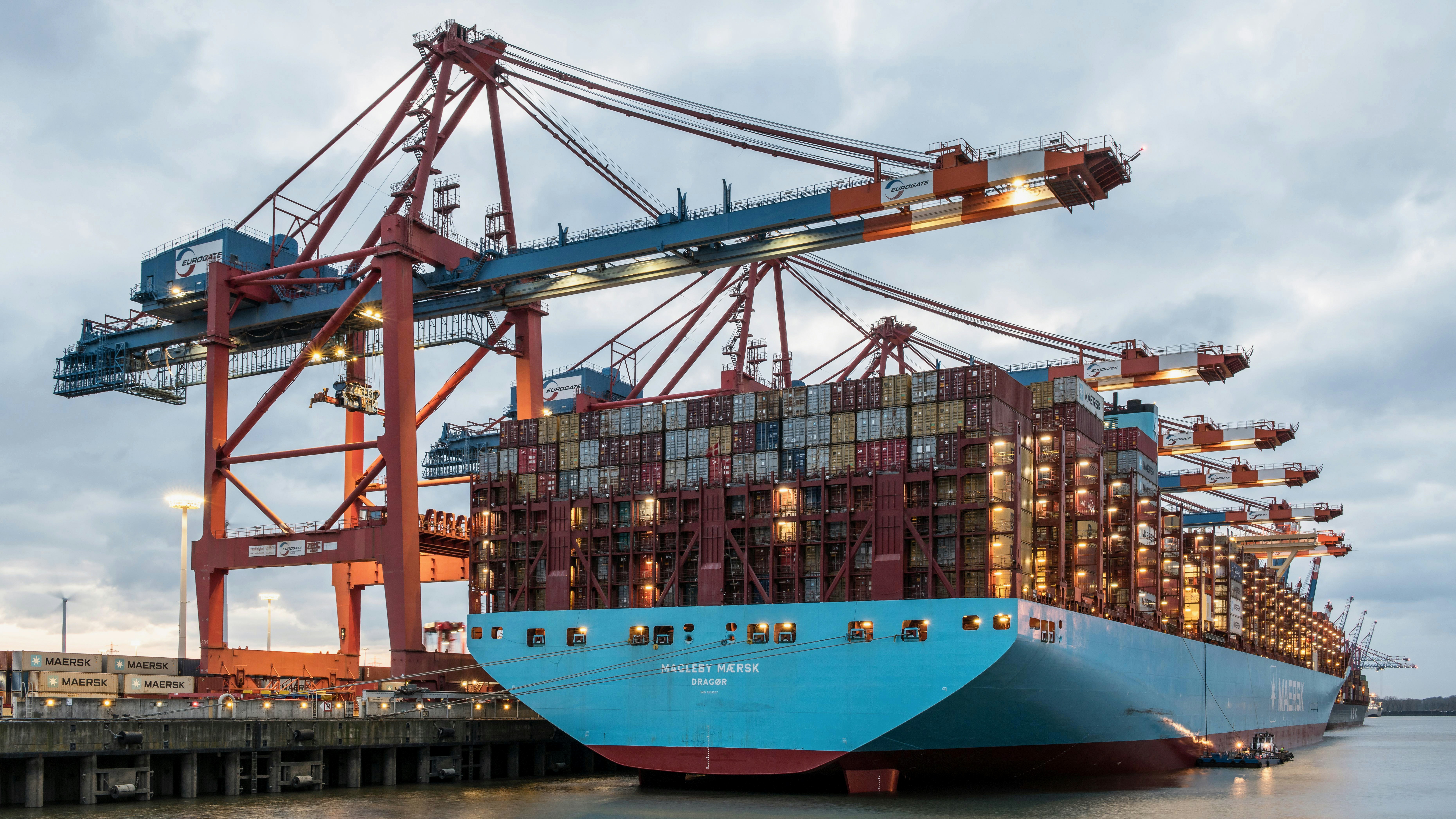 Cargo ship being loaded at port — containers, cranes, and international freight operations